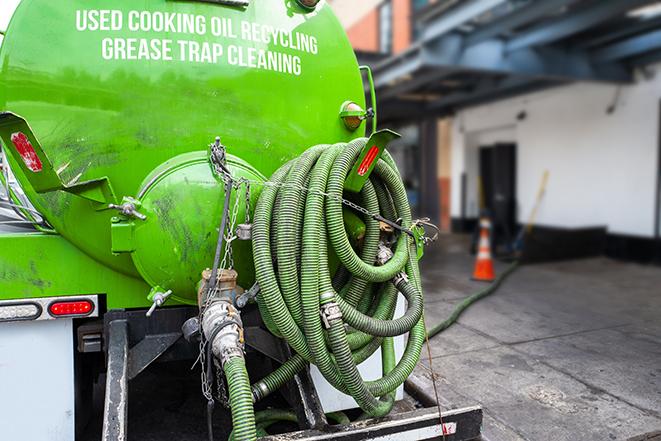 a technician pumping a grease trap in a commercial building in Muskego WI